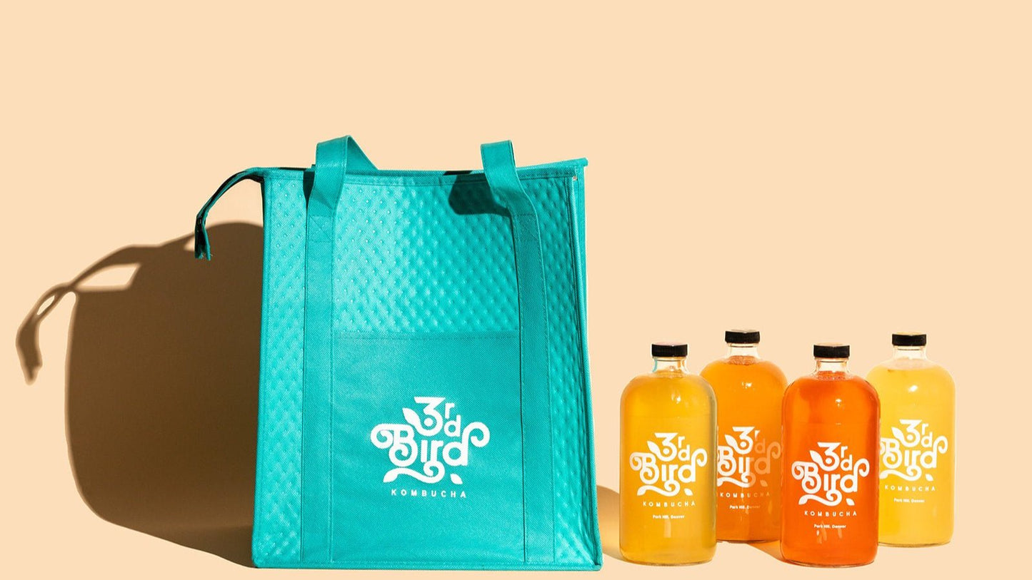 Teal insulated bag with 4 bottles of kombucha