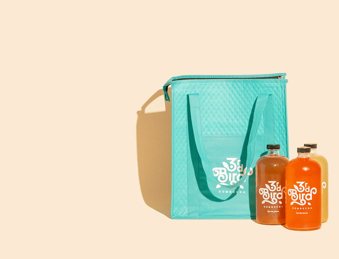 Bottles of Kombucha next to Insulated delivery bag