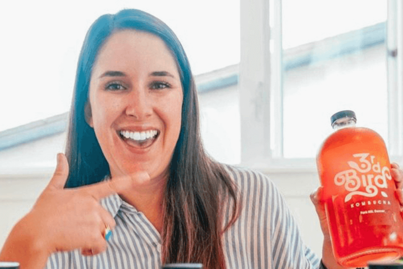 Woman pointing at 3rd Bird Kombucha Bottle