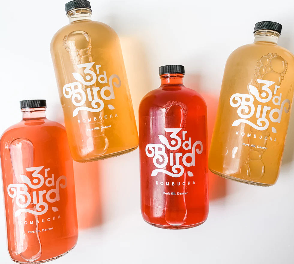 4 different colored bottles of kombucha